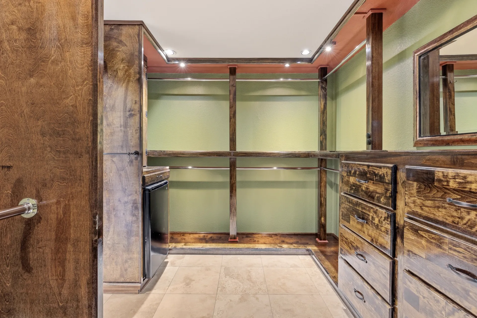 Primary closet with built-in dresser, shelving, and beverage refrigerator