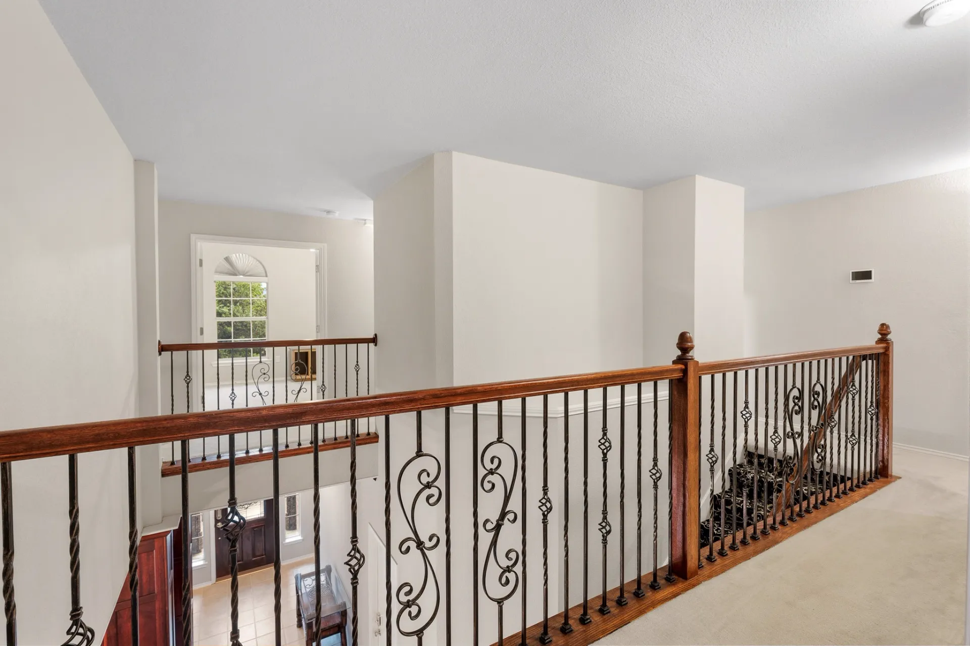 Upstairs landing with wrought iron balustrade overlooking the foyer