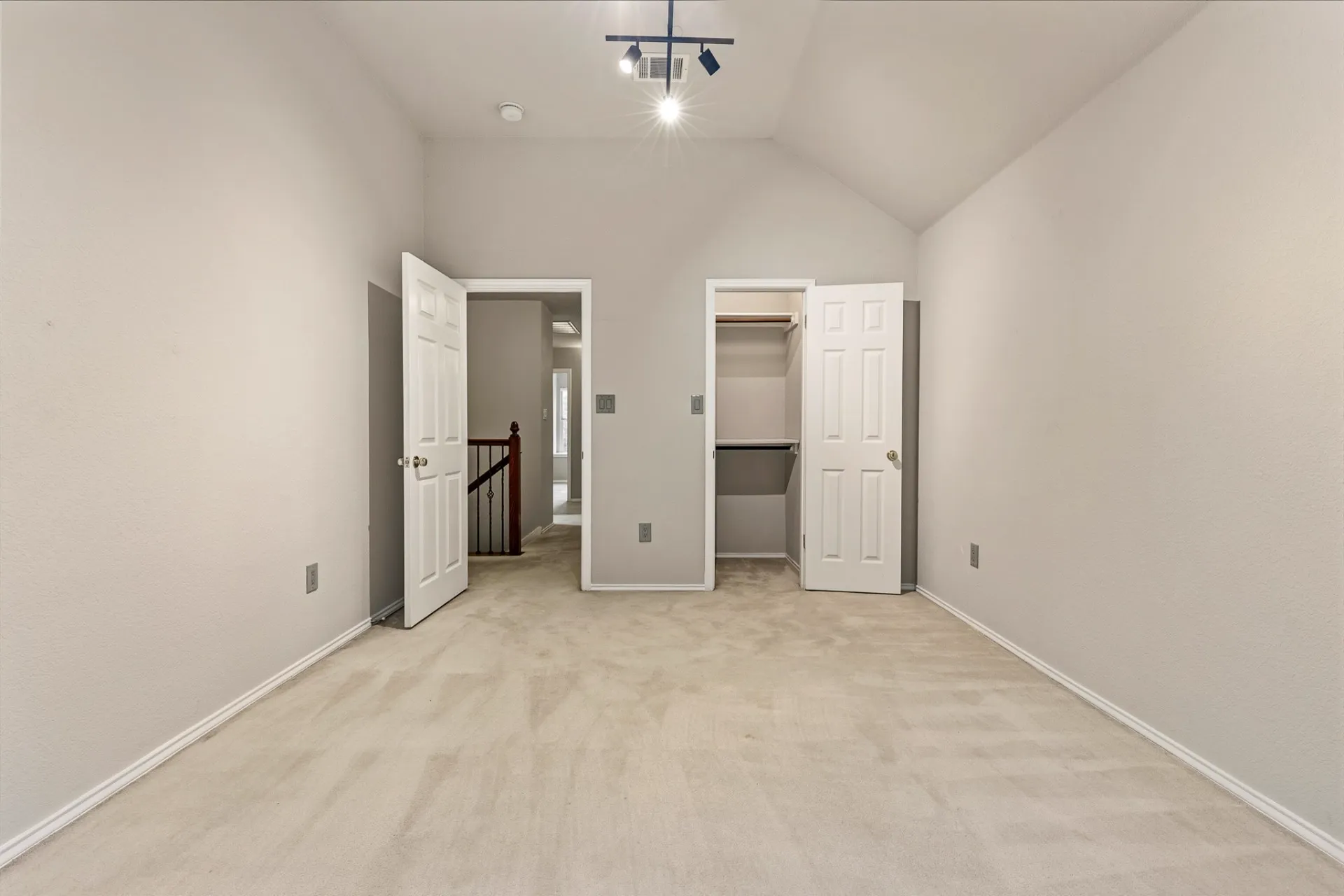 Secondary bedroom with walk-in closet and vaulted ceiling
