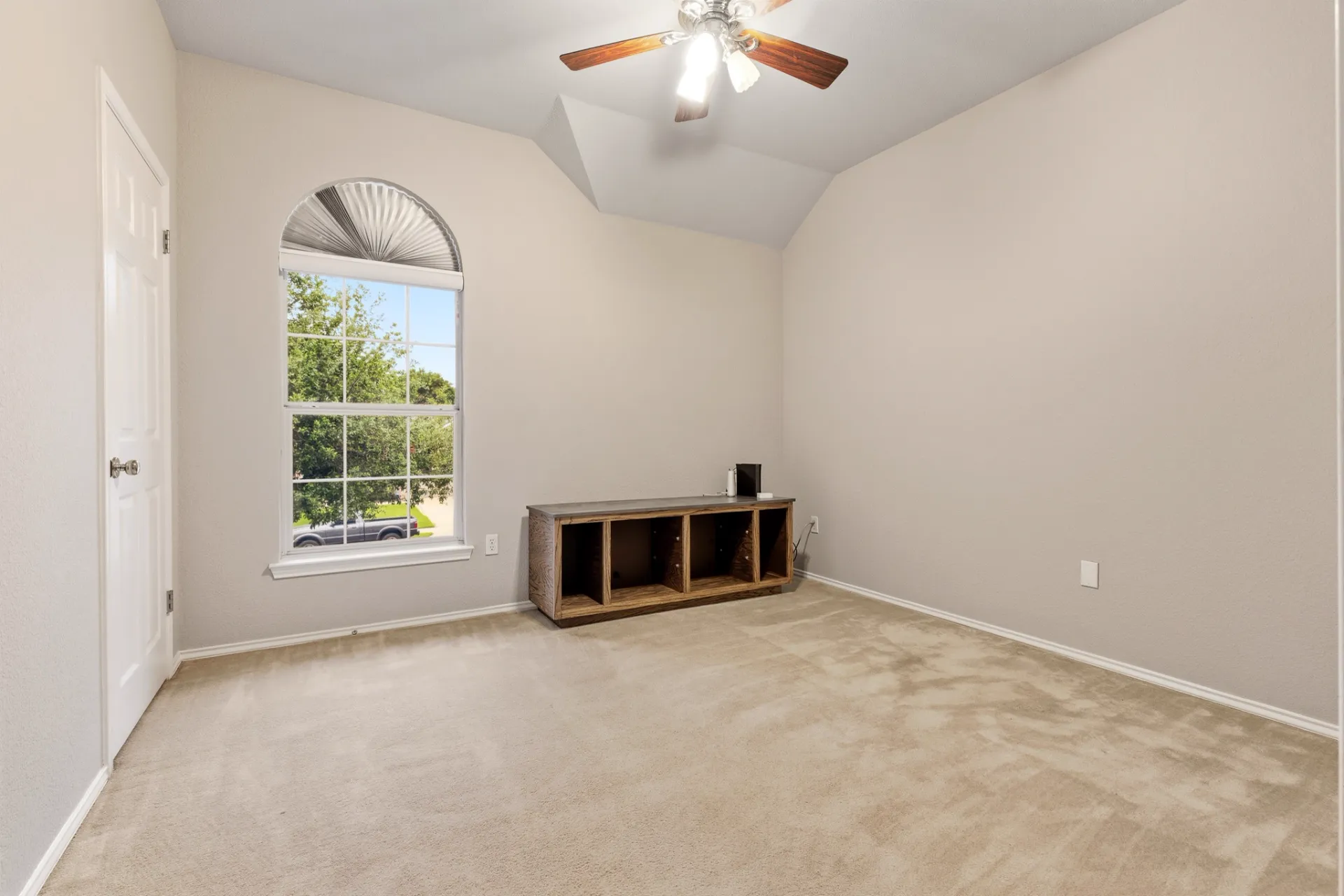 Flex room with arched window and vaulted ceiling, ideal as office or nursery