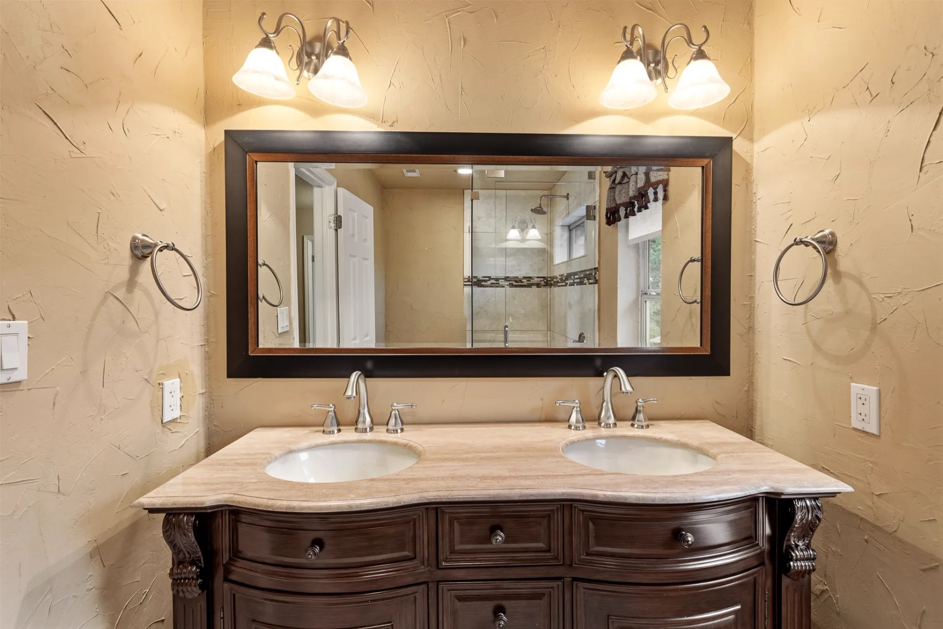 Hall bathroom dual-sink vanity with travertine counter