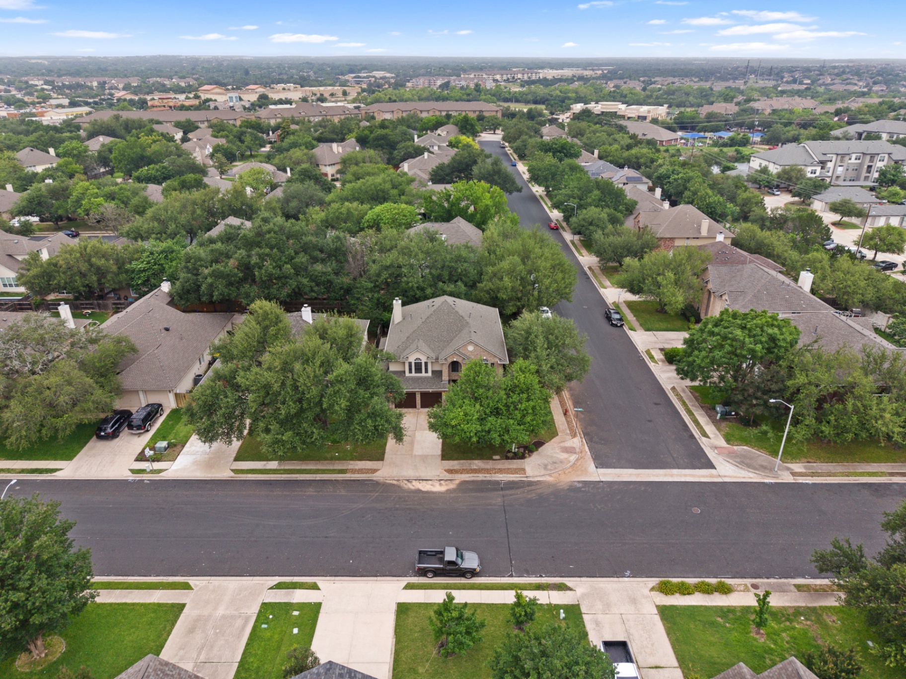 Aerial view showing the surrounding neighborhood and tree canopy